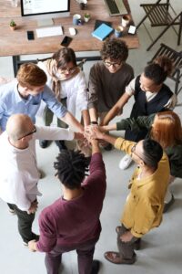 People in a circle with hands extended to the center